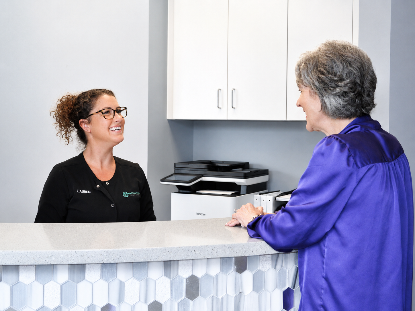 Marble Hill Dentistry team member warmly greeting a patient at the front desk of the Marble Hill, GA office